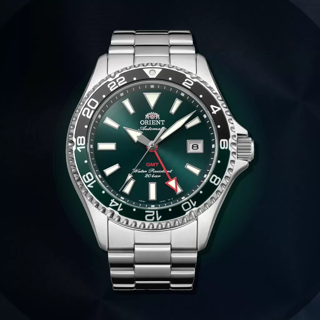 Grüne Orient Mako GMT RA-BC0002E30B vor einem dunklen Hintergrund aus gebürstetem Metall