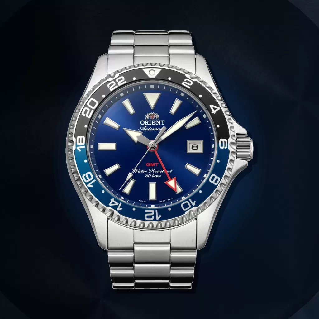 Blaue Orient Mako GMT RA-BC0003L30B vor einem dunklen Hintergrund aus gebürstetem Metall