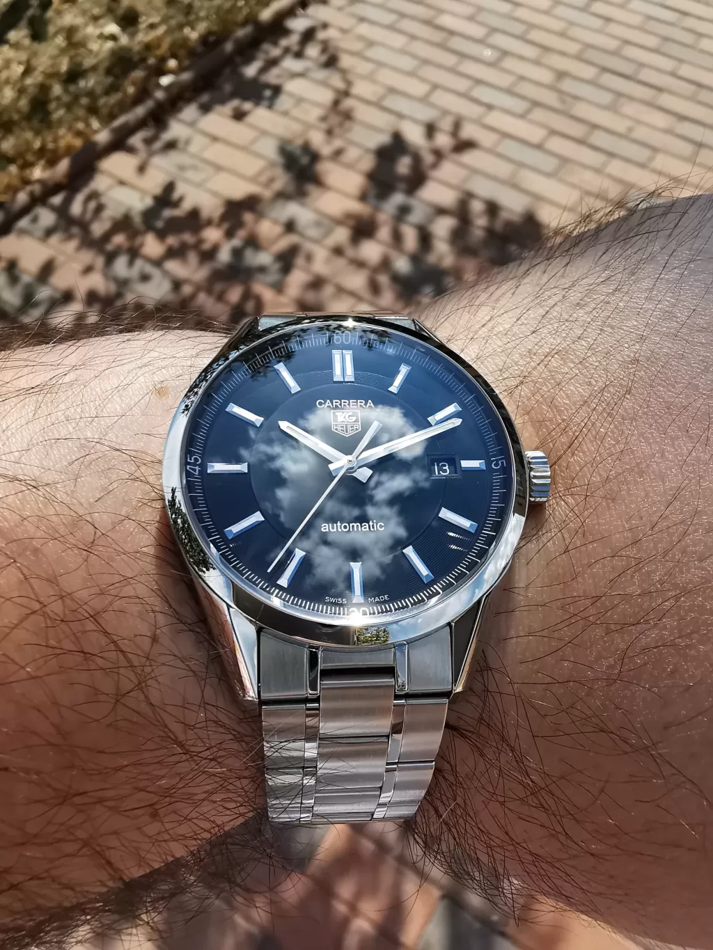 Tag Heuer Carrera Calibre 5 WV211B BA0787の着用写真、風防に映る雲